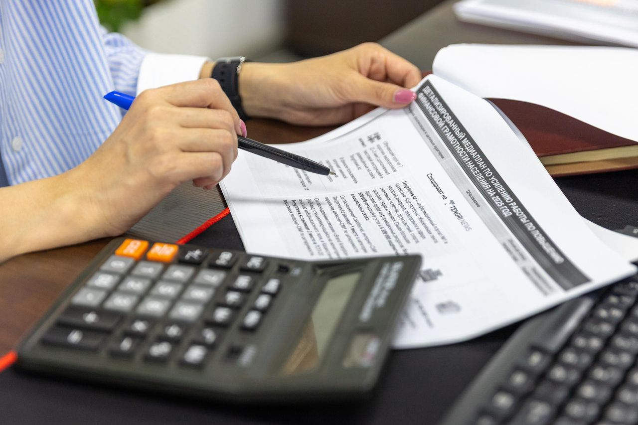 The Art of Drawing Readers In: Your attractive post title goes here Close-up of a person analyzing financial documents using a calculator and pen.