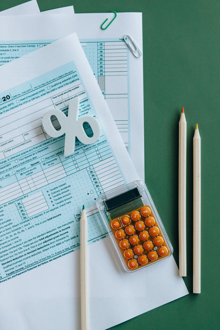 Crafting Captivating Headlines: Your awesome post title goes here Flat lay of tax documents, calculator, and pencils on green surface.