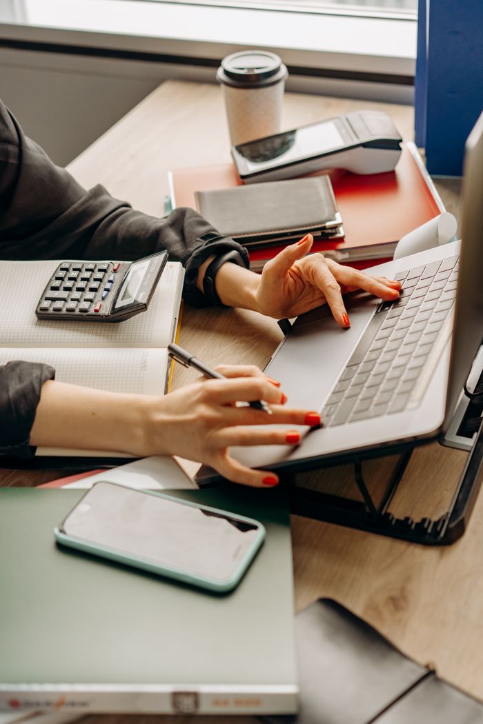 A tidy workspace with a laptop, gadgets, and office supplies on a wooden desk.